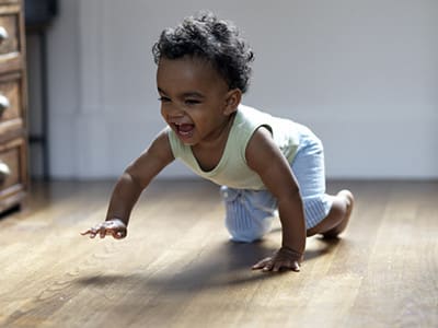 baby crawling on a solid wooden floor