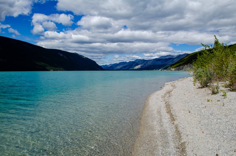 stony beach along a lake with clear blue water