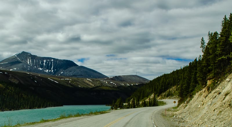 road winding along a lake high in the mountains