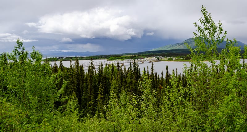 panorama of the bridge leading to teslin, a town on the water