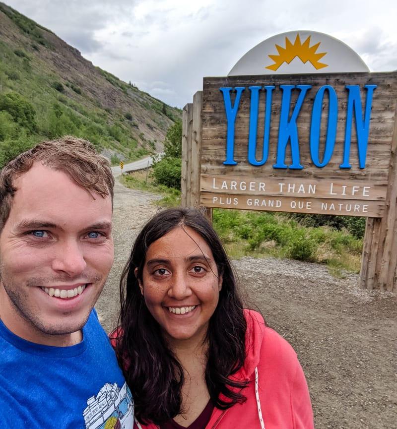 will and sushila by the welcome sign for the yukon