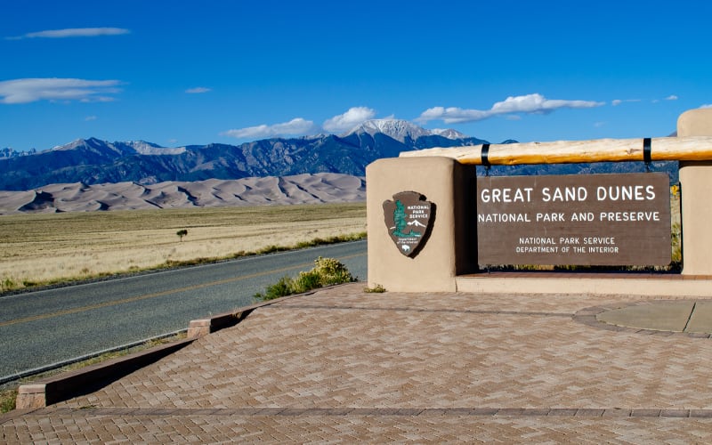 national park sign with dunes in the background