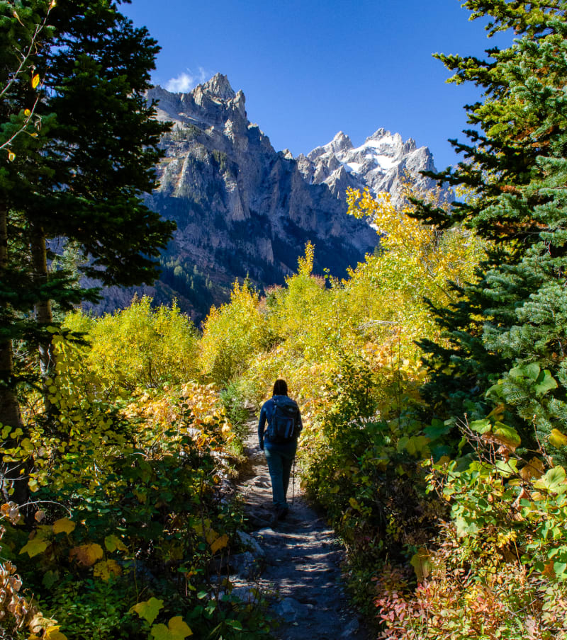 sushila on the trail with mountains in the background