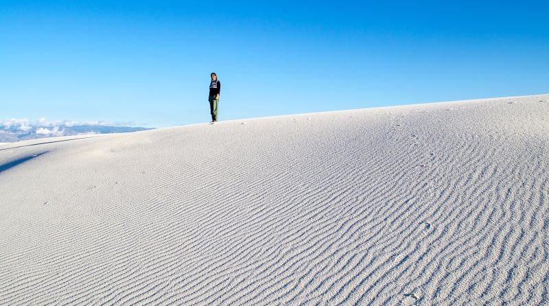 sushila atop a dune that is covered in wave-like ripples