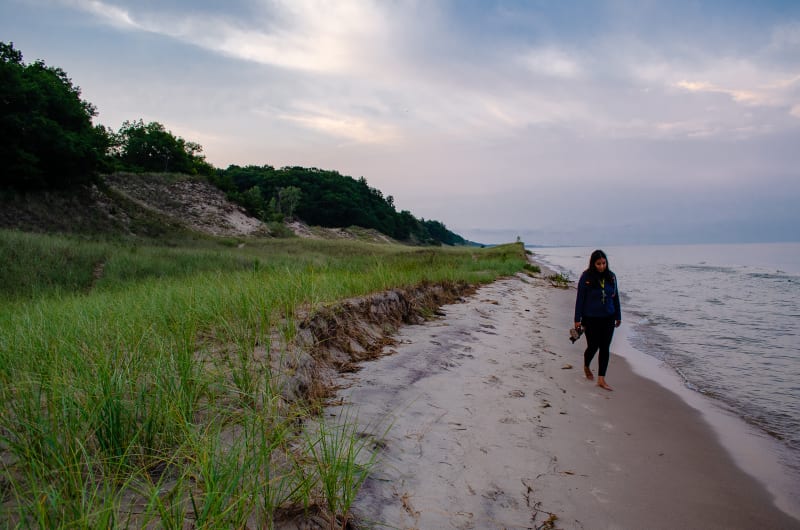 sushila walking along the lakeshore at hoffmaster state park