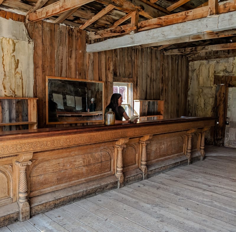 sushila standing behind the bar in one of the buildings