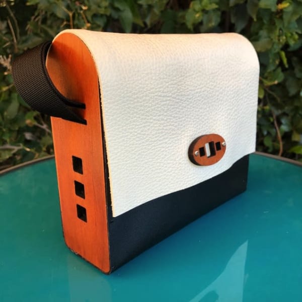 Laser cut wood and leather bag-handcrafted from upcycled materials. Adjustable  woven strap allows these gorgeous bag to be worn cross body or as a shoulder bag. Exterior measures 7 inches x 6 1/4 inches tall by 2 3/8 inches. More styles and color combos available on web site.