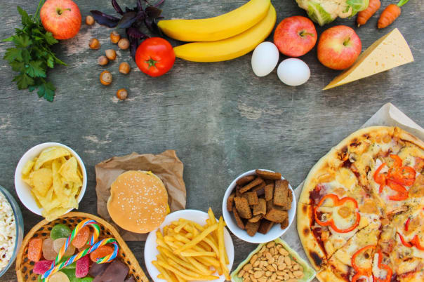 Fastfood and healthy food on old wooden background