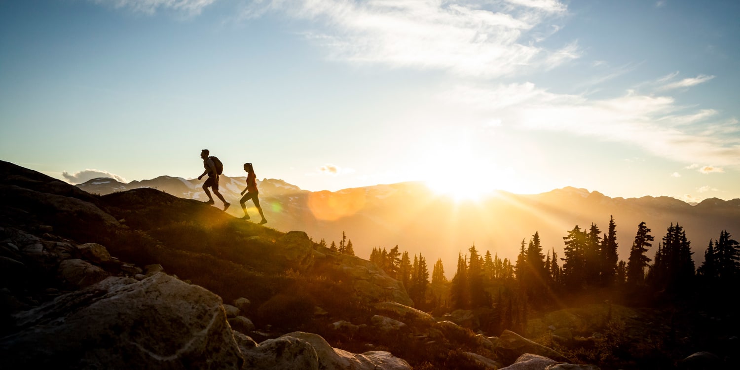 two people hiking at sunset