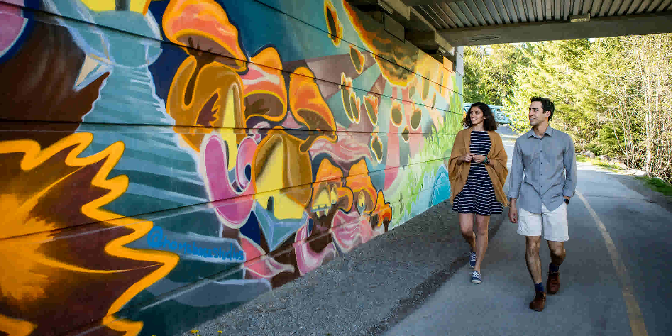 Couple looking at a mural in the Village on a Go Whistler self-guided tour