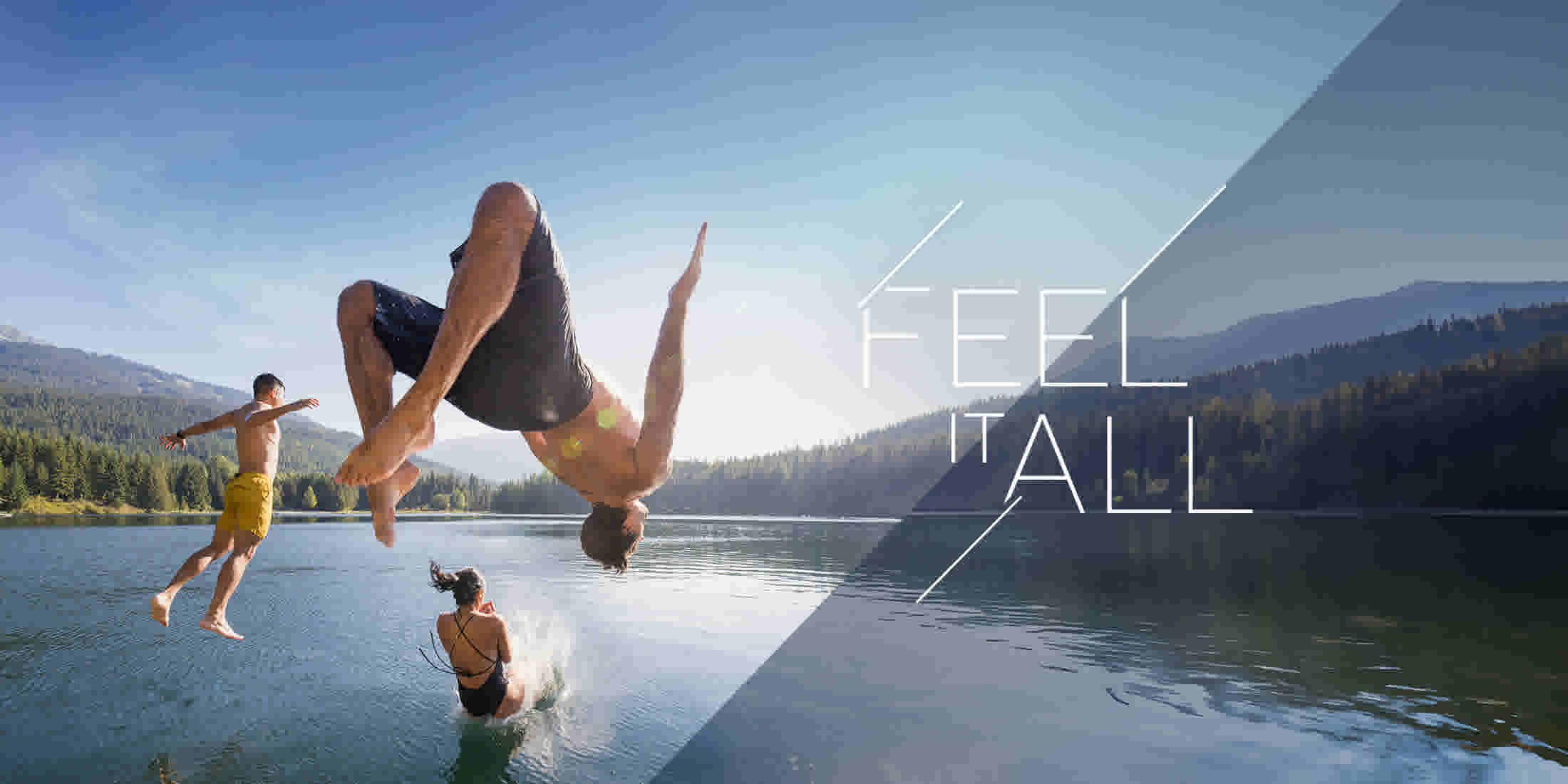 Three people jumping off a dock into a lake in Whistler BC