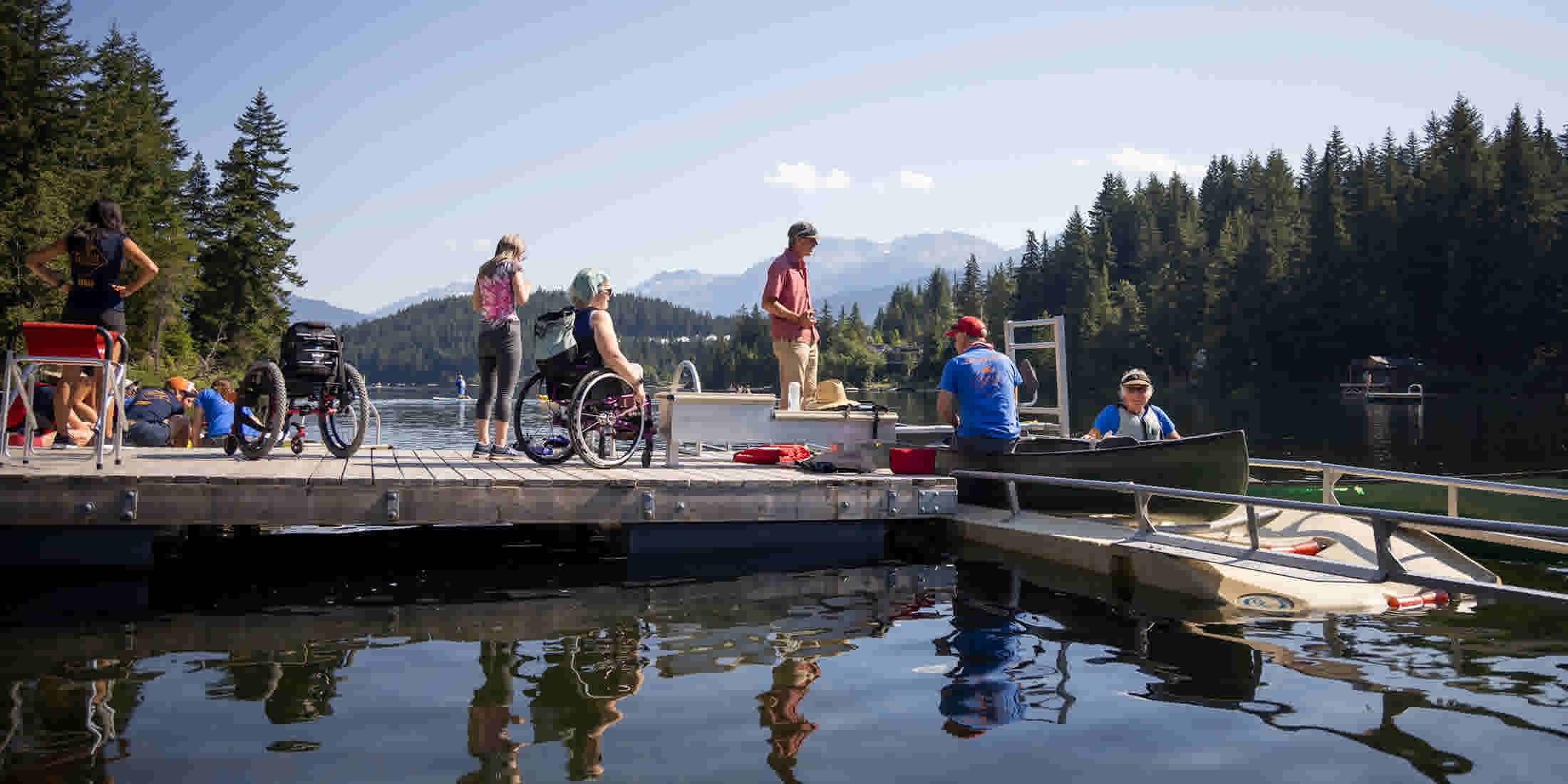 Whistler Adaptive assisting people in wheelchairs to get into watercraft on Alta Lake in Whistler