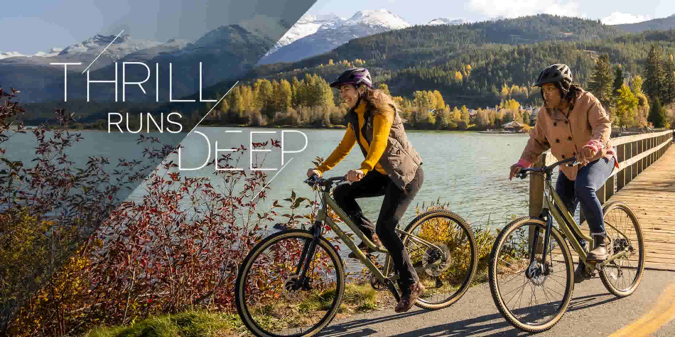 Two people biking on the Valley Trail by Green Lake in the fall in Whistler