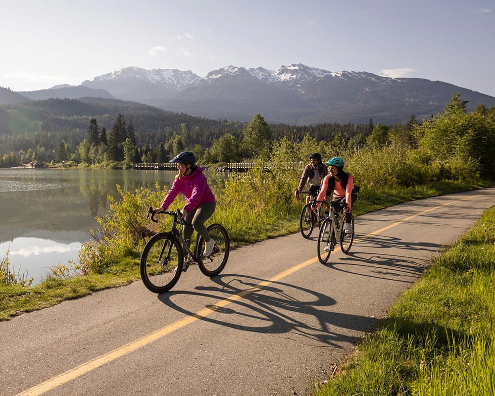 Threee people riding bikes on the Whistler Valley Trail in spring