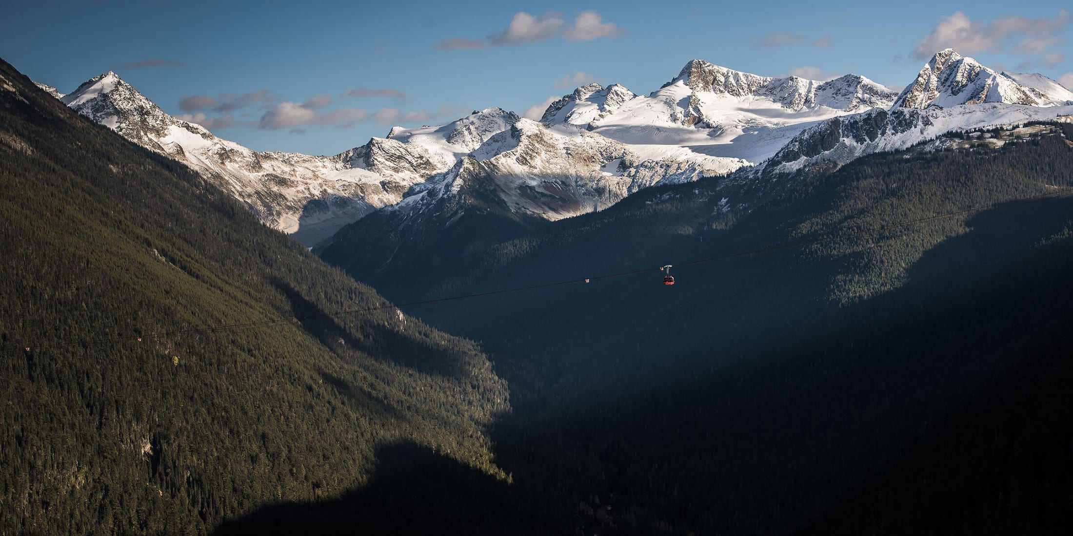 View of the record-breaking PEAK 2 PEAK Gondola with snowy mountain peaks and the Valley below.