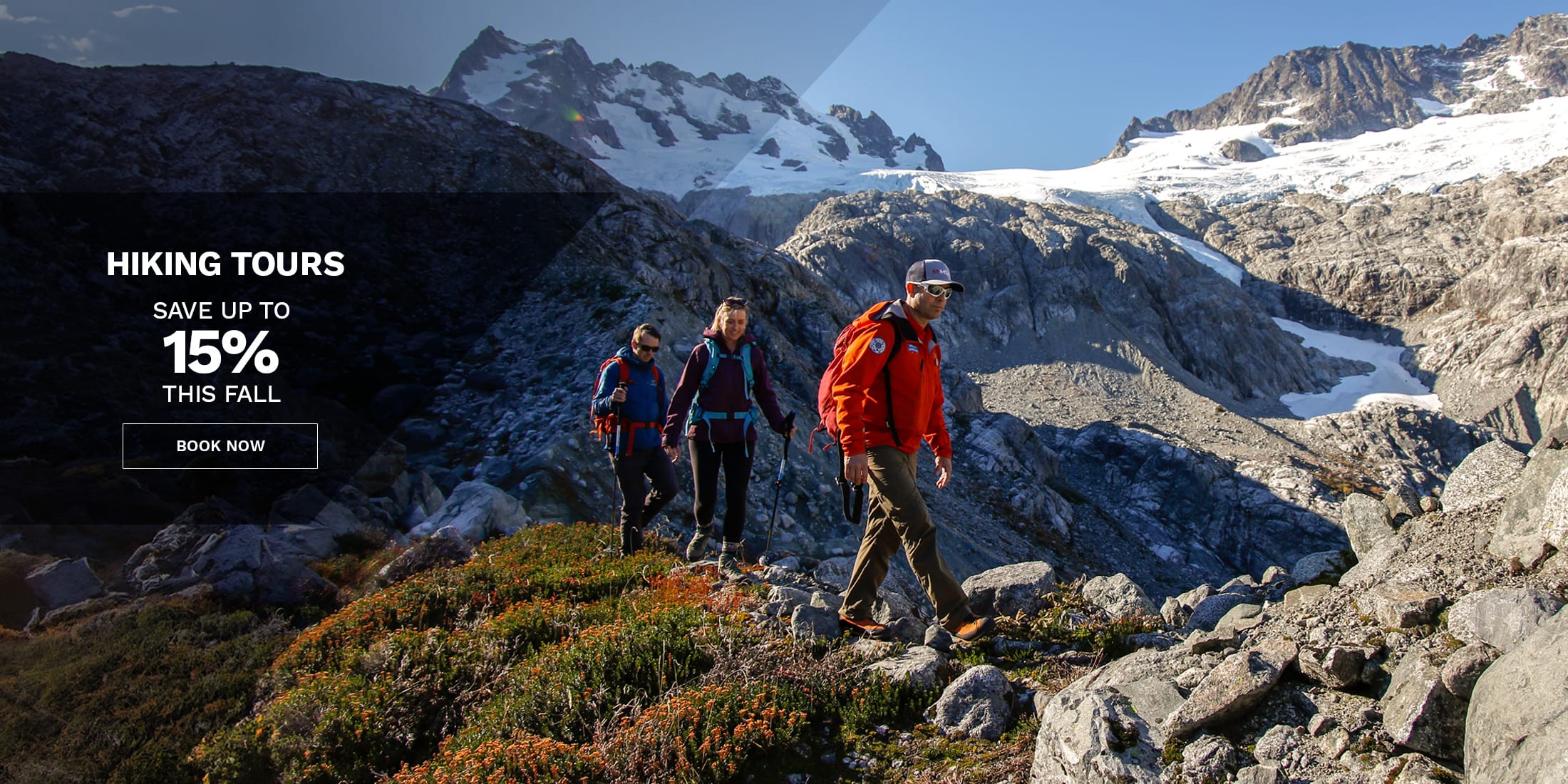 Hiking tours promotion featuring two hikers standing on rocky alpine terrain beside a calm mountain lake with reflections, surrounded by rugged peaks under dramatic skies; overlay text reads “Hiking Tours – Save up to 15% this summer” with a “Book Now” call to action.