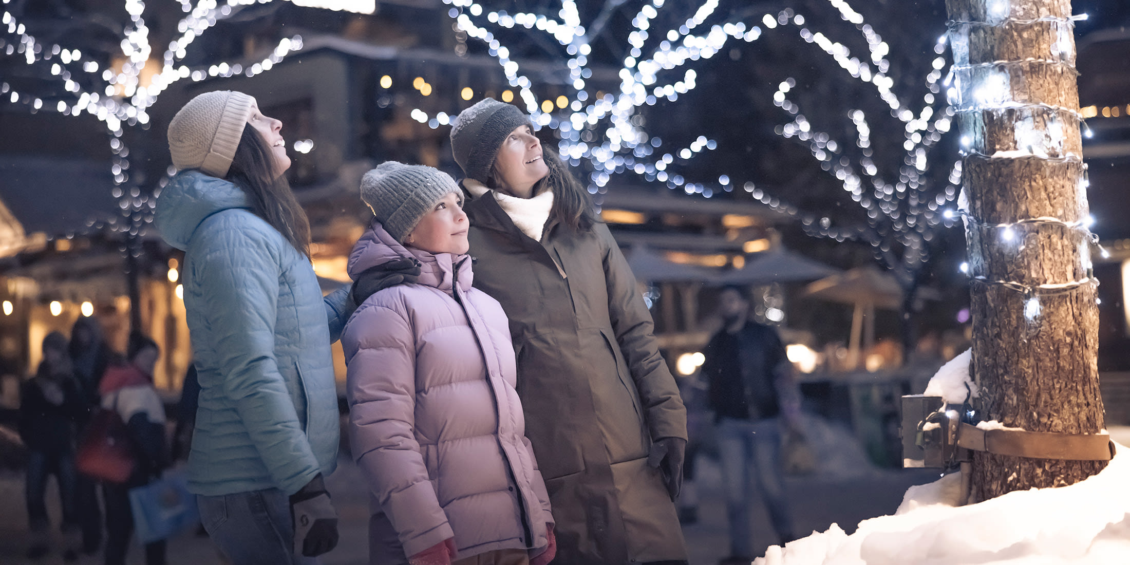 Family enjoying the Village Stroll in Whistler, British Columbia on a snowy winter eventing