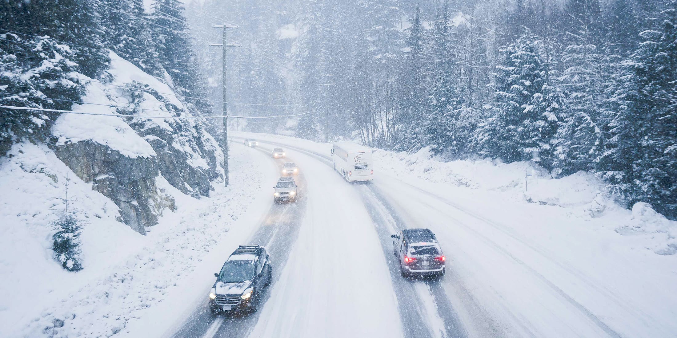 Vehicles travel along the snow-covered Sea to Sky Highway during a winter snowfall on the way to Whistler.