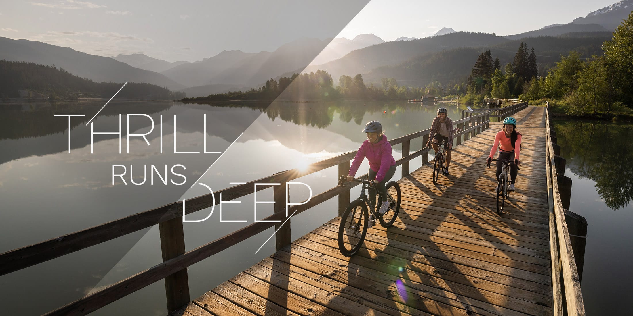 Three people riding bikes on the Valley Trail at Green Lake in Whistler British Columbia Canada