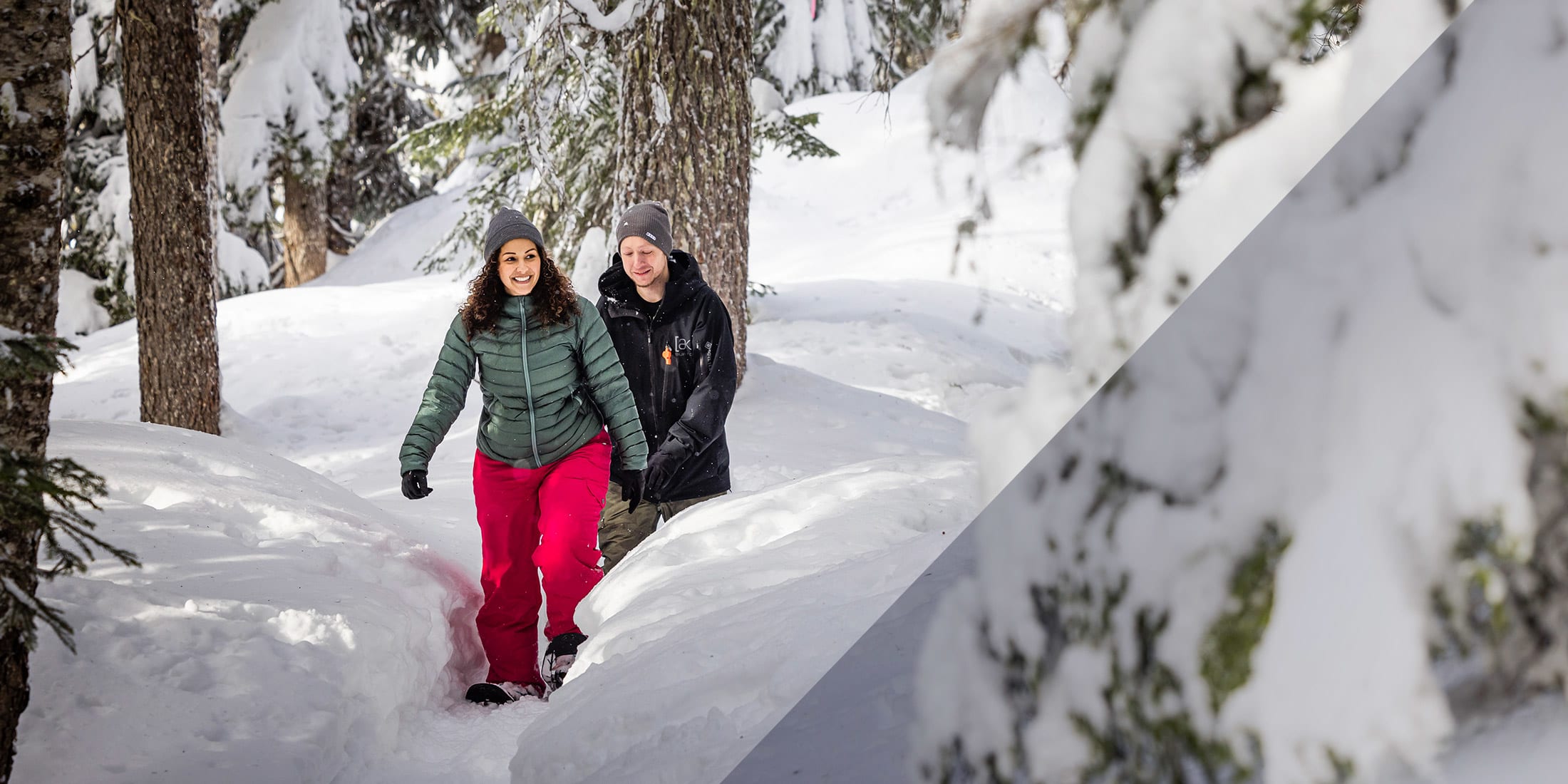 Two people snowshoeing in deep snow in the forests of Whistler