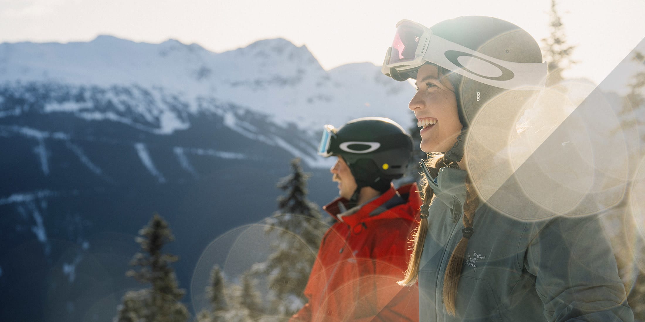 A closeup of two smiling skiers standing on the slopes of Whistler Blackcomb in the sunshine on a spring day