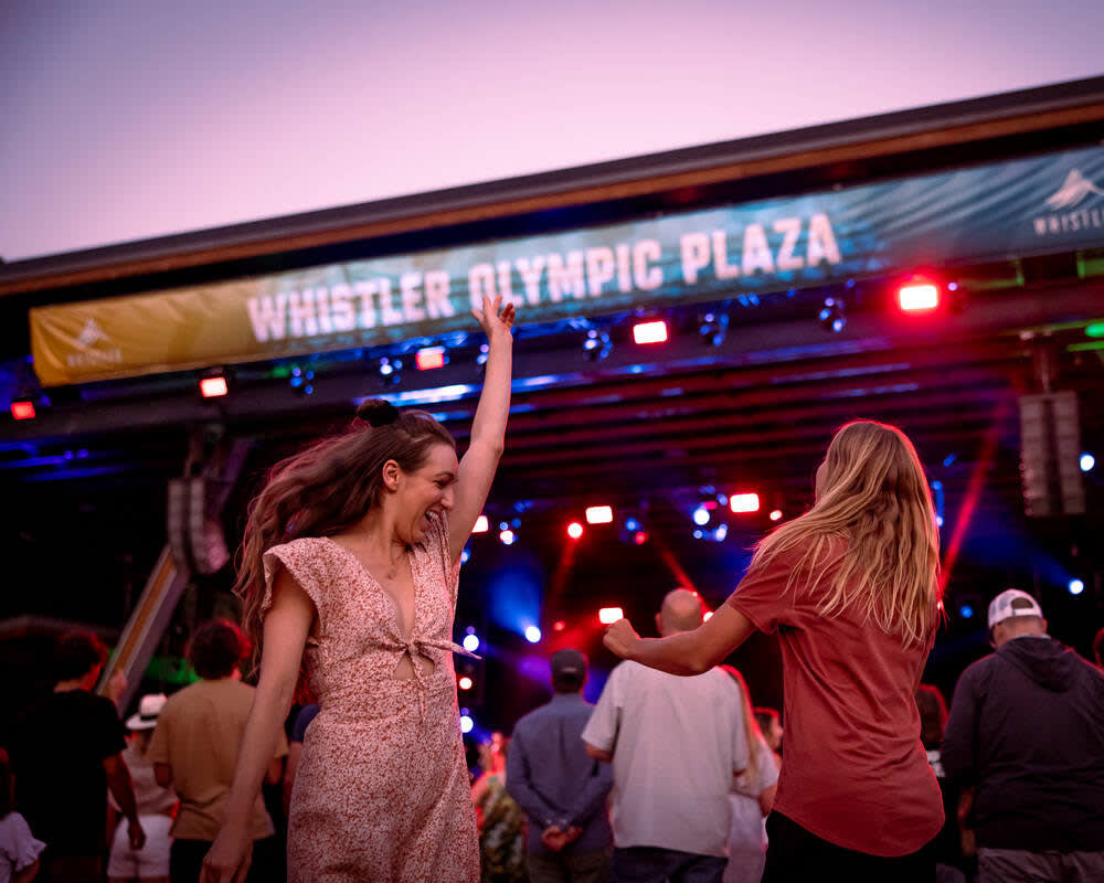 People dancing and smiling at Whistler Summer Concert Series in Whistler Olympic Plaza