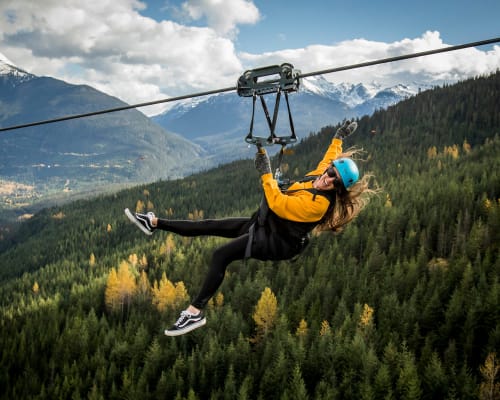 A person ziplining through the mountains in spring in Whistler