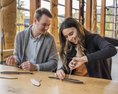 Couple taking part in an Indigenous craft workshop at the Squamish Lil’wat Cultural Centre.