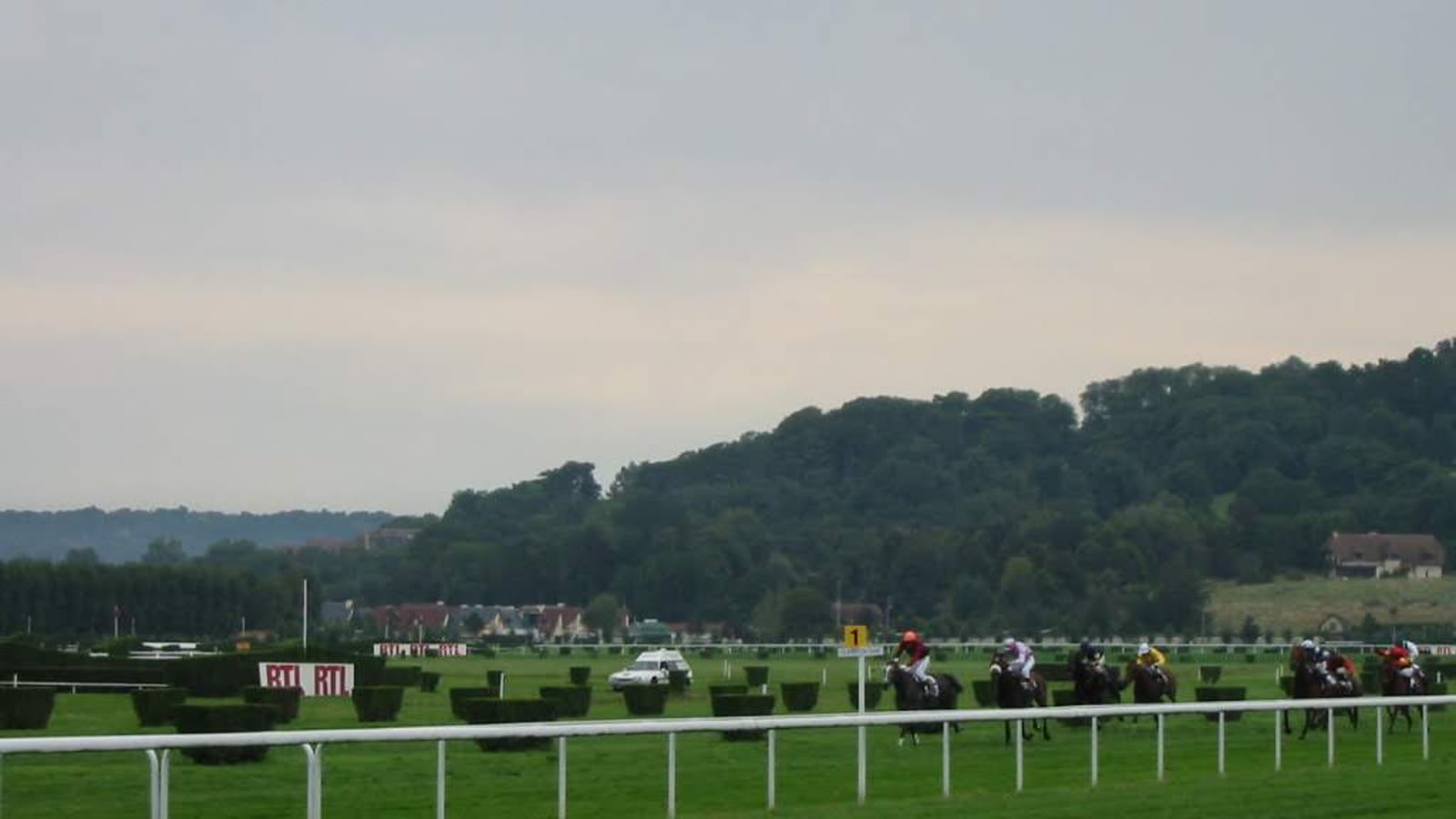 Un groupe de chevaux en course sur l'hippodrome de Deauville
