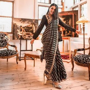 Flaunt your curves by draping a black stripped saree paired with a plain long sleeved blouse Flaunt your curves by draping a black stripped saree paired with a plain long sleeved blouse