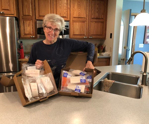 Member Susan K. smiling next to her new box