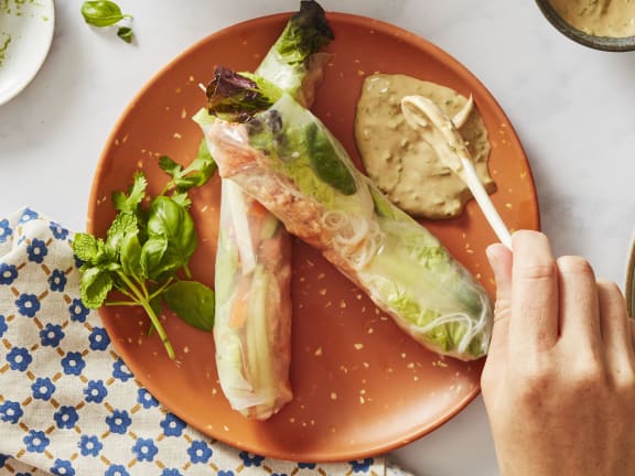 coho salmon in summer rolls with vegetables on plate