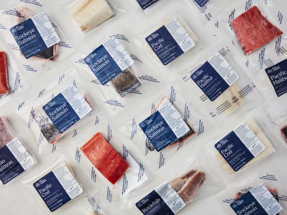 a selection of frozen fish fillets in packaging with wild alaskan company labels