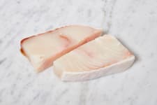 Raw halibut steaks on marble cutting board