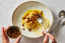 cod fillet with saffron butter and raisins in a shallow bowl