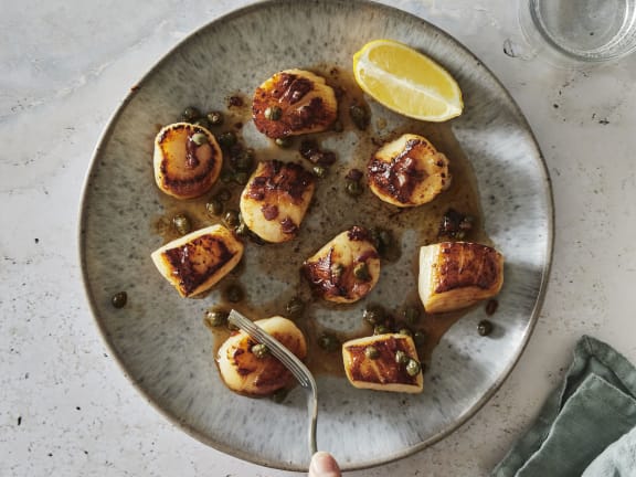 seared weathervane scallops with caper butter sauce on plate