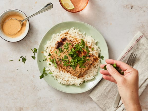 fillet of breaded pacific halibut on rice with coconut curry sauce