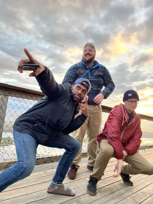 Three Wild Alaskan team members pose in front of Kachemak Bay in Alaska