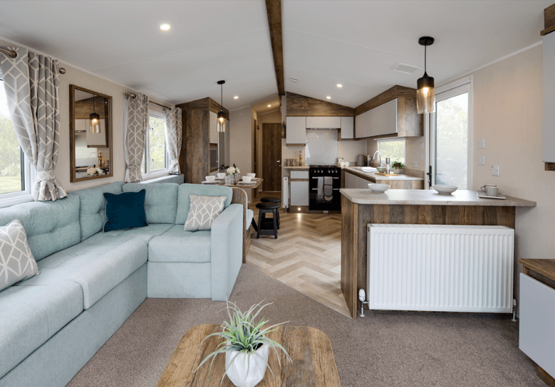 The Willerby Brookwood lounge with sage green fixed seating and a oak effect coffee table.