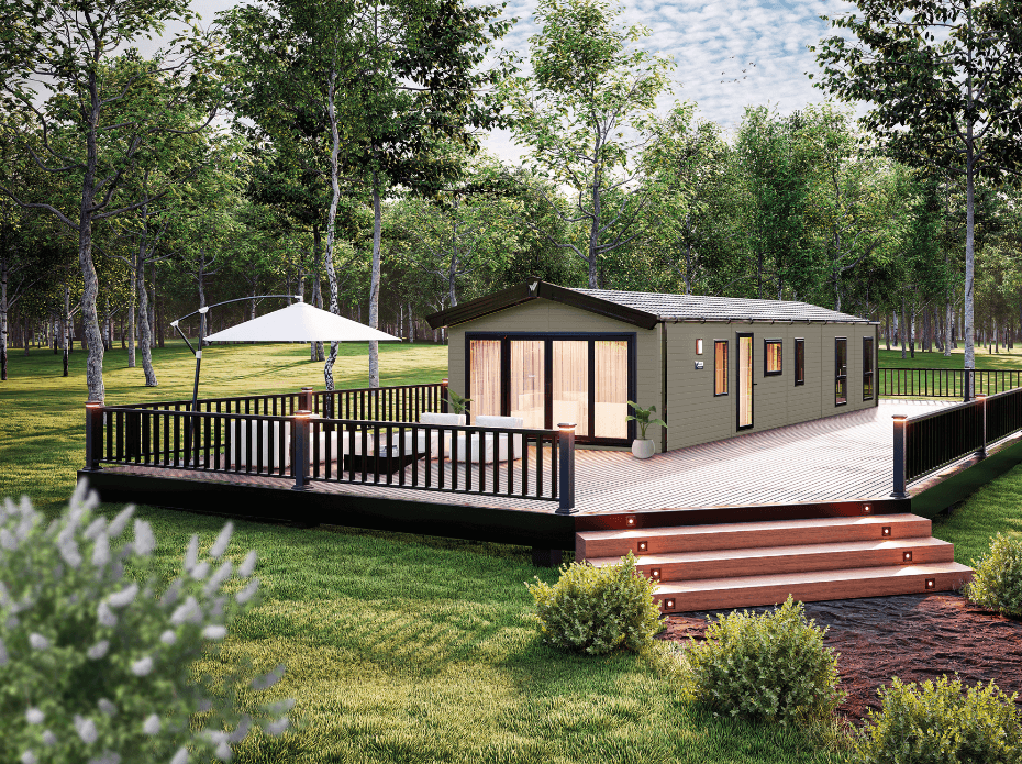 The Willerby Dorchester exterior in environmental green with a wide brown and black decking sited on a grassy field.