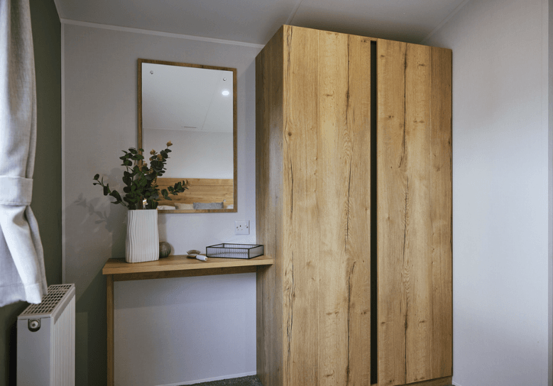 The Willerby Ellerton Extra compact dressing area with oak effect storage units.