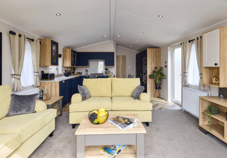 The Willerby Gainsborough lounge has pale yellow freestanding sofas and an oak effect coffee table.