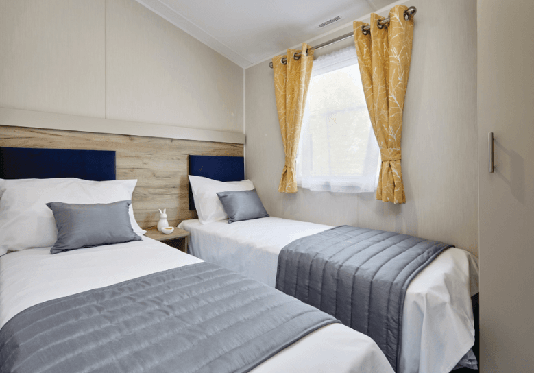 The Willerby Linwood twin bedroom has upholstered dark blue headboards.