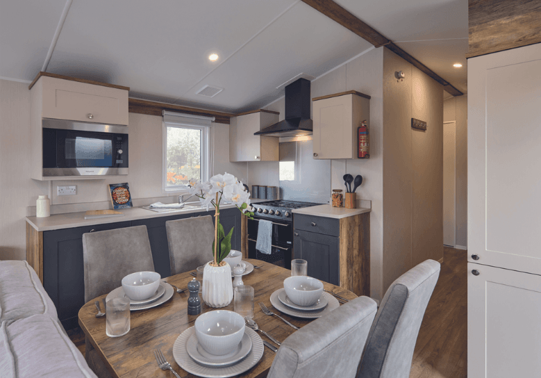 The Willerby Malton kitchen has cream and grey cupboard doors with a matching cream worktop.