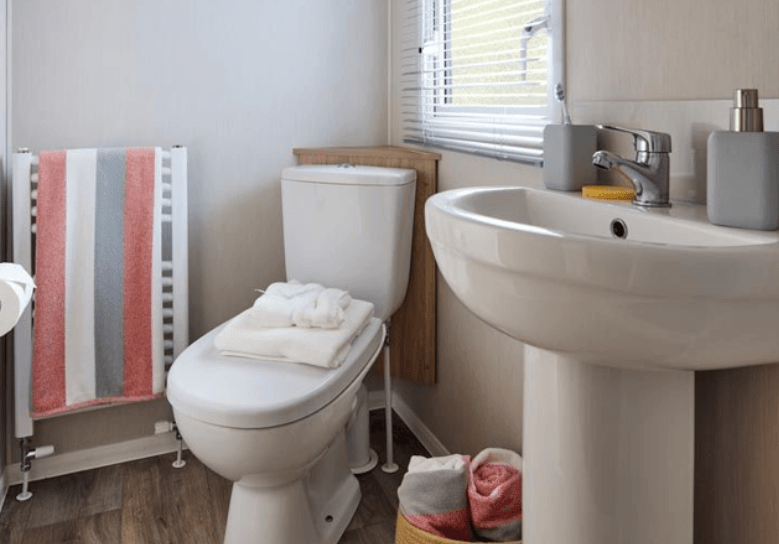 The Willerby Manor bathroom with oak effect units and colourful towels.
