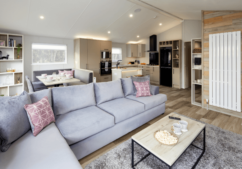 The Willerby Mapleton lounge has a grey L-shaped freestanding sofa with a small coffee table is the center.