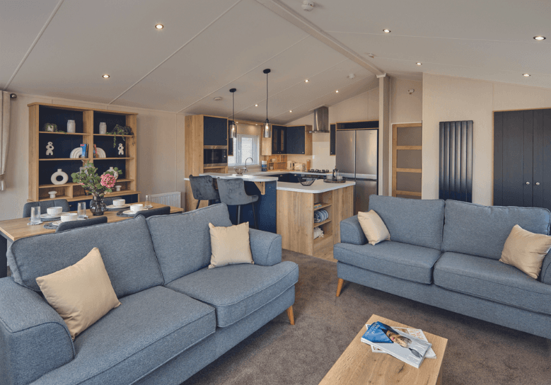 The comfortable free-standing sofas of the Willerby New Holland holiday lodge. Behind them is the open-plan kitchen diner. There is plenty of space. 