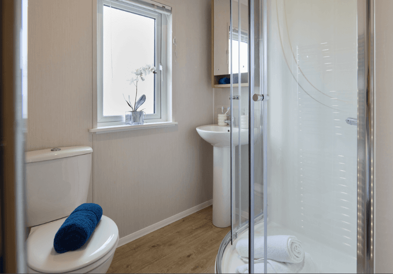The Willerby New Holland ensuite has oak effect flooring with a shower pod.