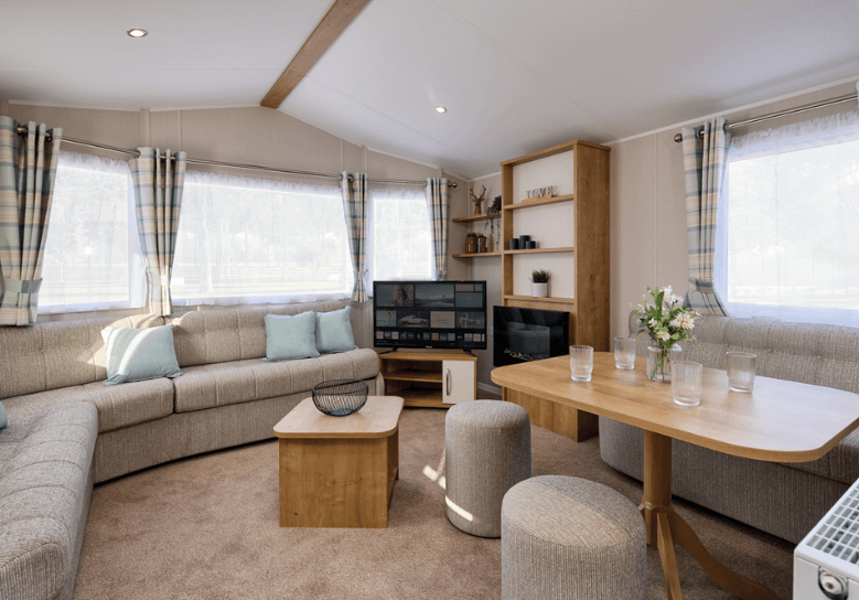 The Willerby Richmond lounge has a grey L-shaped sofa with an oak effect coffee table in the center of the room, with a matching media unit and dining area.