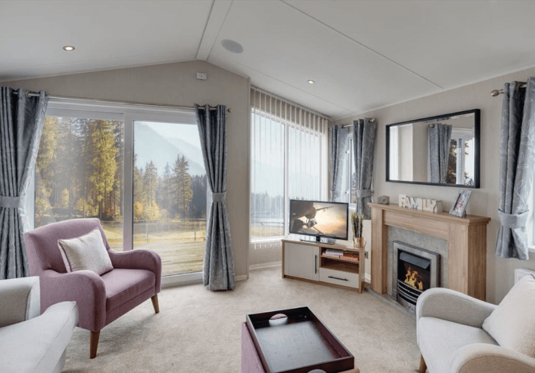 The Willerby Waverley lounge has three freestanding sofas, two are single arm chairs, in grey and pink with a matching mink coffee table, and it has oak effect storage units.